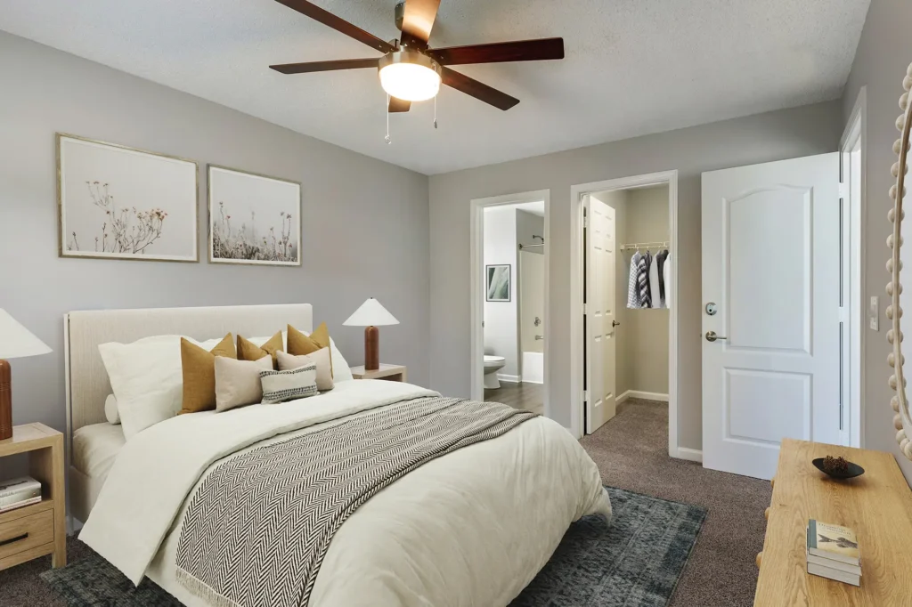 Bedroom with ceiling fan, walk in closet, and private bath