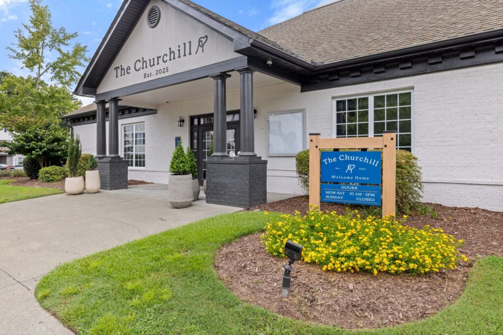 outdoor view of leasing office with welcome sign and landscaping