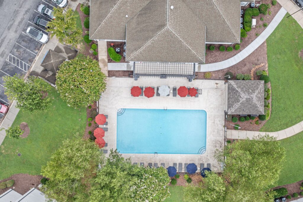 Outdoor swimming pool with patio and lounge seating with umbrellas