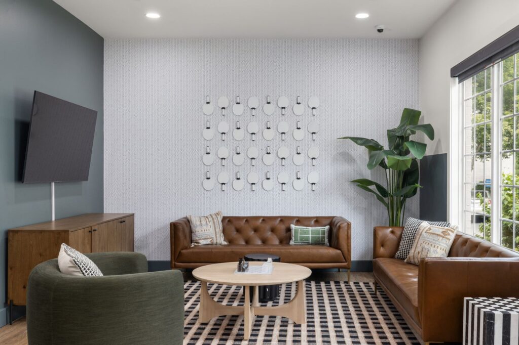 lounge space with sofas and chairs, wall mounted television