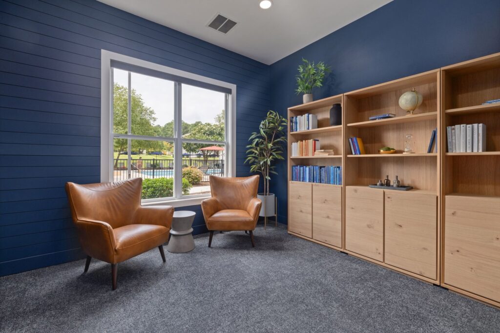 reading space with bookshelves lining the wall and two lounge chairs